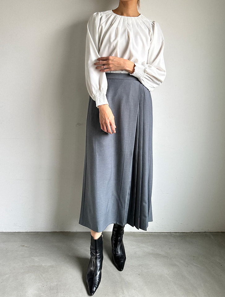 フロントタックプリーツブラウスの白とグレーのスカートを合わせた、清潔感のある春のレディース・オフィスカジュアル